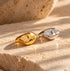 Reneax and Company gold and silver molten sculptural statement rings on a textured stone surface